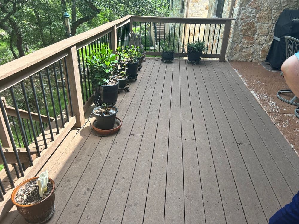 Deck with potted plants, showcasing outdoor living space and greenery in a residential setting.