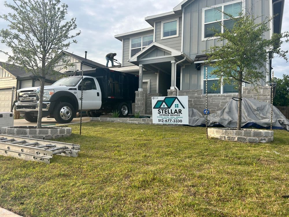 Stellar Services truck parked in front of a house with landscaping work in progress.